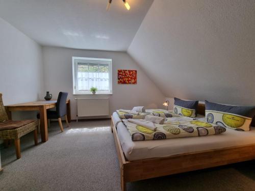a bedroom with a bed and a table and a window at Ferienhaus Claudia in Norden