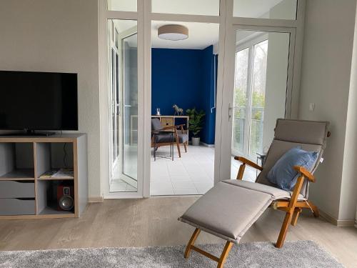 ein Wohnzimmer mit einem Stuhl und einem TV in der Unterkunft Apartment am See Bad Saarow in Bad Saarow
