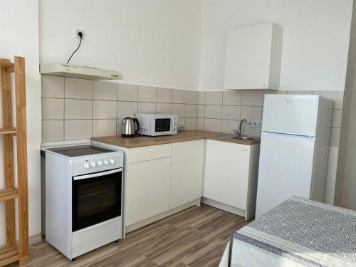 eine kleine Küche mit einem Herd und einem Kühlschrank in der Unterkunft ЖК Sat City блок С in Astana
