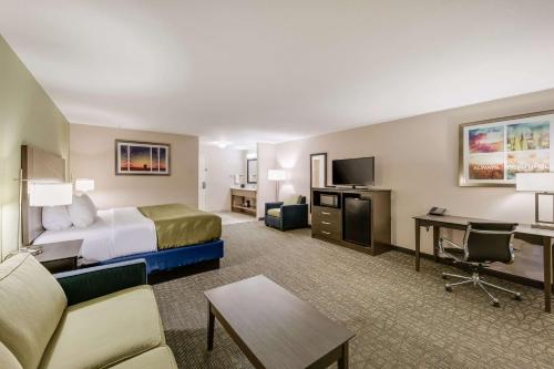 a hotel room with a bed and a living room at Quality Inn & Suites Ardmore in Ardmore