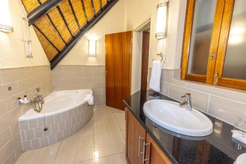 ein Badezimmer mit einer Badewanne und einem Waschbecken in der Unterkunft Legend Safaris 257B - in Kruger Park Lodge in Hazyview