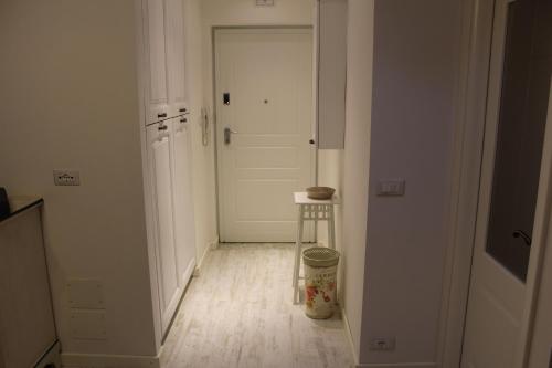 a hallway with a white door and a stool at Tana Bianca in Trieste