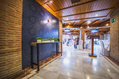 a hallway with a blue wall and a table with plants at Nuevo Torreluz in Almería