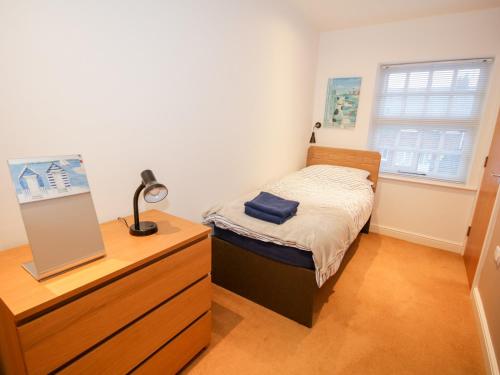 a bedroom with a bed and a dresser with a mirror at 9 The Oakleys in Porthmadog
