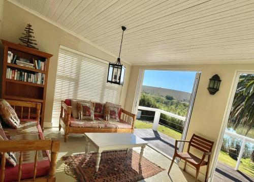 ein Wohnzimmer mit Sofa und Tisch in der Unterkunft Living The Breede - Birdsong Cottage in Malgas