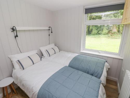 Bett in einem kleinen Zimmer mit Fenster in der Unterkunft Saltwater in Haverfordwest