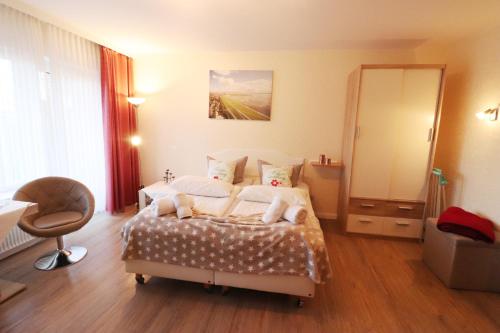 um quarto com uma cama, uma cadeira e um espelho em Haus Laura Wohnung 1 em Büsum