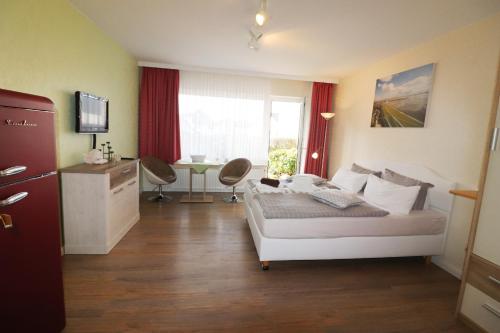 um quarto com uma cama branca e uma janela em Haus Laura Wohnung 1 em Büsum