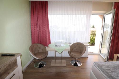 um quarto com uma mesa e duas cadeiras e uma janela em Haus Laura Wohnung 1 em Büsum