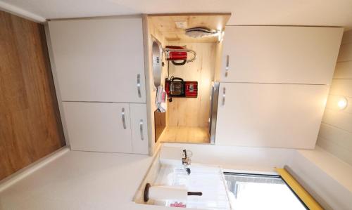 uma pequena cozinha com um lavatório e um espelho em Haus Laura Wohnung 1 em Büsum