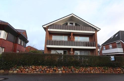 uma casa de tijolos com uma cerca em frente em Haus Laura Wohnung 1 em Büsum