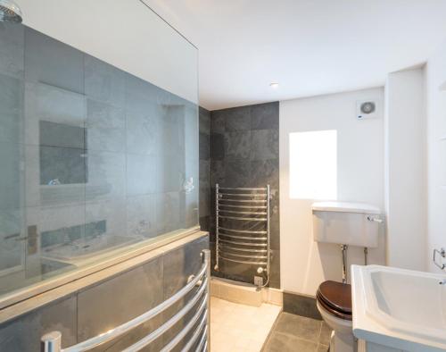 a bathroom with a tub and a toilet and a sink at Orchard Cottage in Saint Endellion