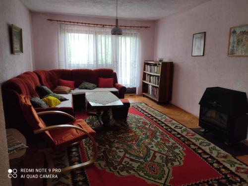 sala de estar con sofá rojo y mesa en MeD apartmani en Bugojno