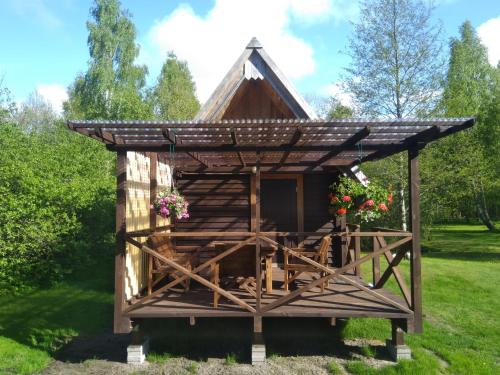 a wooden dog house with a roof at Pie Andra Pitragā in Pitragutsiyeme