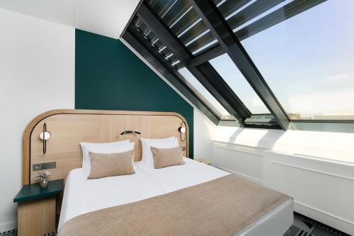 a bedroom with a bed and a window at Hotel Oktogon Haggenmacher by Continental Group in Budapest