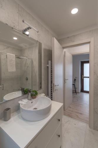 a white bathroom with a sink and a bath tub at La corte di Silvia CENTRO in Sesto Calende