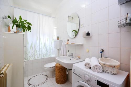 La salle de bains blanche est pourvue d'un lavabo et de toilettes. dans l'établissement Artsy Apartment, à Klis