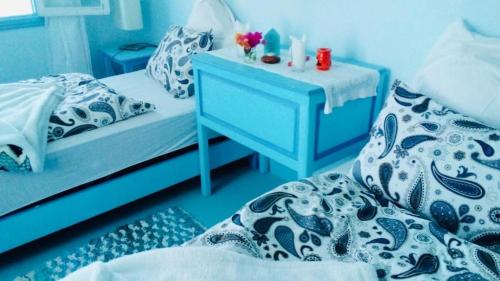 a blue bedroom with a bed and a nightstand with a blue table at Pretty room in villa Lair De La Mer, in Sidi Kaouki in Sidi Kaouki