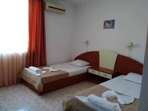 a hotel room with two beds and a window at Family hotel Dramchev in Nesebar
