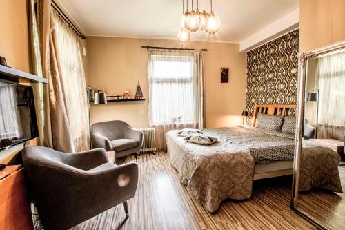 a bedroom with a bed and a chair and a television at Quiet Romantic Studio plus parking, Tartu Home in Tartu