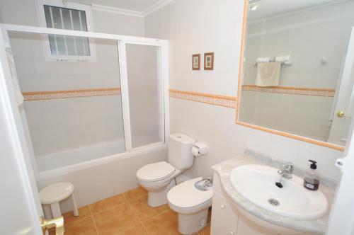 a white bathroom with a toilet and a sink at AMANECER vista mar Orangecosta in Benicàssim