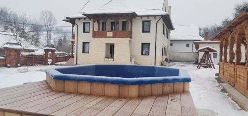 uma grande banheira azul sentada num deque de madeira em Pensiunea ARMONIA em Văleni