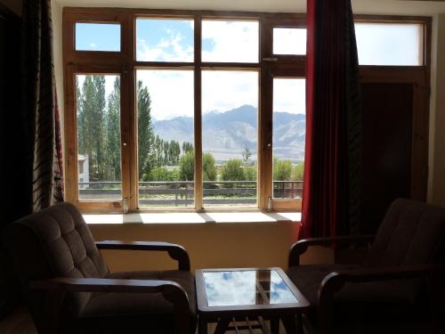 a room with a window with a view of mountains at Orion Home in Leh