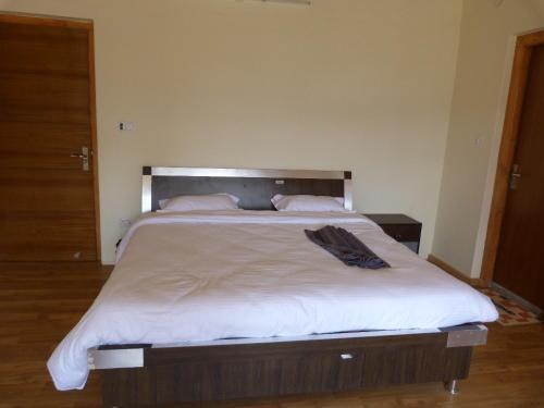 1 dormitorio con 1 cama grande con sábanas blancas en Orion Home, en Leh