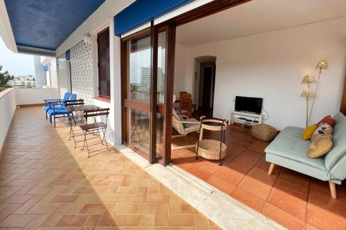 ein Wohnzimmer mit einem Sofa, einem Tisch und Stühlen in der Unterkunft Apartment on the beach by amcf in Alvor