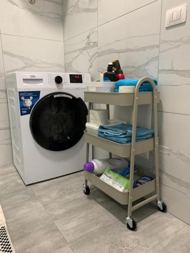 a washing machine with a cart in front of it at Lovely 1-bedroom Condo in Tirana WiFi-Netflix-AC in Tirana