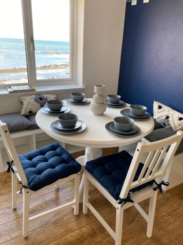a dining room with a table and chairs with a view of the ocean at Ugly Duckling, License number FI 00863 P in Fife
