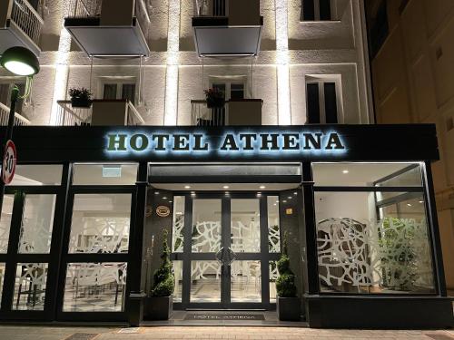 a hotel athtarhtarhtarvelt is lit up at night at Hotel Athena in Lignano Sabbiadoro