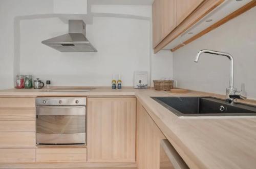 a kitchen with a sink and a stove at Copenhagen City Apartment with cosy backyard in vibrant area in Copenhagen