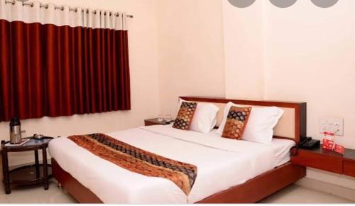 a bedroom with a large bed with a red curtain at Hotel Durga Silverline in Jodhpur