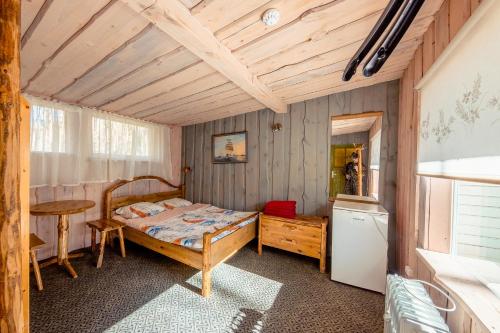 a bedroom with a bed and a table and a refrigerator at Villa Marika Holiday Centre in Alajõe
