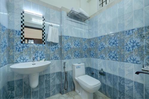 a blue tiled bathroom with a toilet and a sink at Kurinji Wanderlust Resort Munnar in Munnar