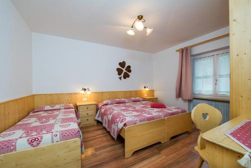 A bed or beds in a room at Majon Vajolet - Apartments Luisa