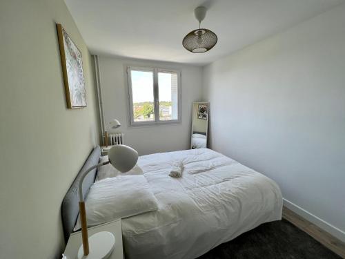 um quarto branco com uma cama e um candeeiro em SUPERBE APPARTEMENT AVEC VUE IMPRENABLE em Castelnau-le-Lez