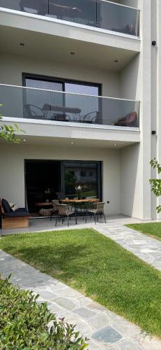 a house with a patio with a table and benches at MOLA PAPAYA STUDIOS in Mola Kalyva