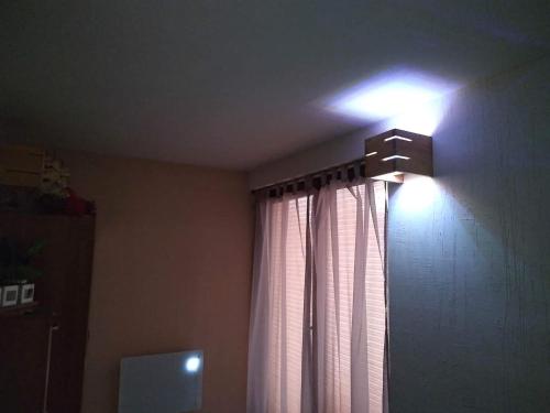 a light on the ceiling of a room with a window at Morska Bryza in Chłopy