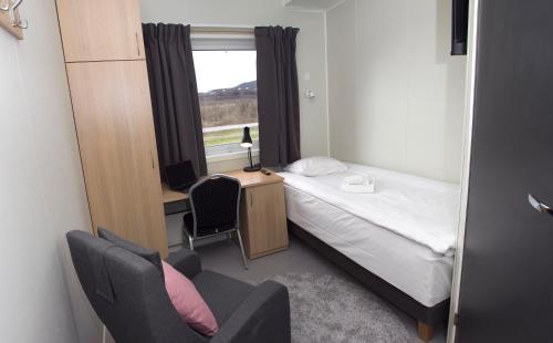 a bedroom with a bed and a desk and a window at Kiruna City Room in Kiruna