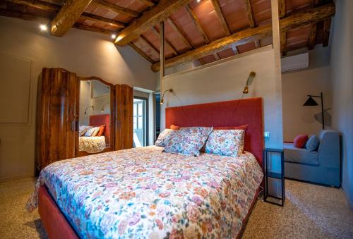 a bedroom with a large bed and a blue couch at Il Molino Carlotta House in Porto Ercole