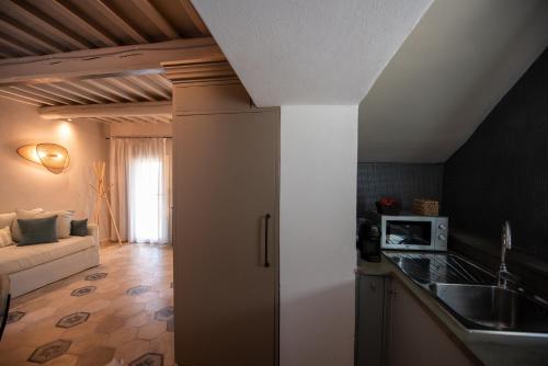 a kitchen with a sink and a couch in a room at Il Molino Carlotta House in Porto Ercole