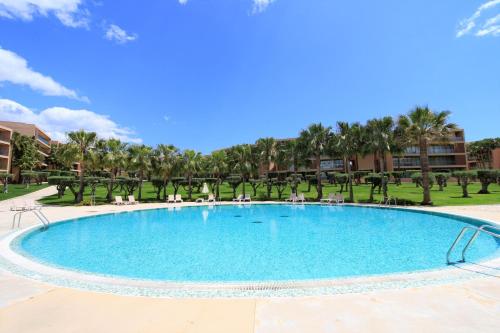a large swimming pool in a resort with palm trees at Albufeira Salgados Premium 1 With Pool by Homing in Guia