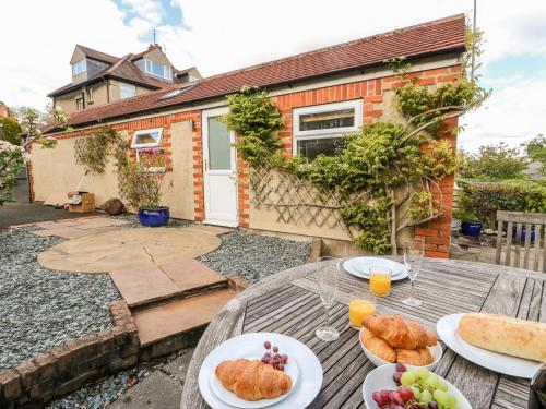 a table with plates of bread and fruit on it at Garden Cottage in Ilkley