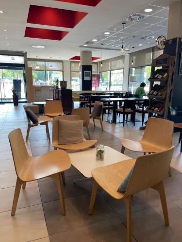 a restaurant with tables and chairs in a cafeteria at Ibis Ripollet in Ripollet