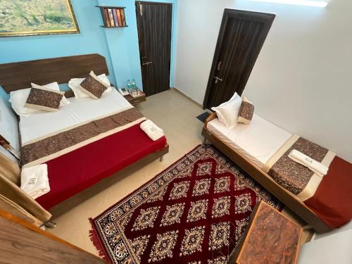 2 camas en una habitación con alfombra en un dormitorio en Vrindavan Comfort Inn, en Ameerpet
