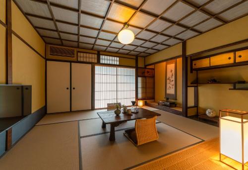 a large room with a table and a kitchen at The Machiya Kamiumeya in Kyoto