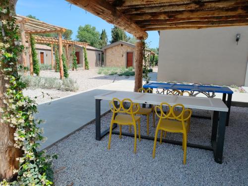 a table and yellow chairs under a pavilion at Agriturismo Resort Il Foionco in Massa Marittima