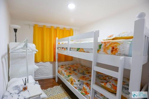 1 dormitorio con 2 literas y cortina amarilla en Casa de Cima - Casal de Loivos - Pinhão, en Casal de Loivos
